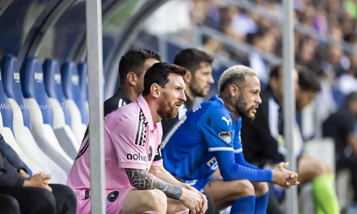 Lionel Messi and Neymar looking disappointed on the bench due to injuries.