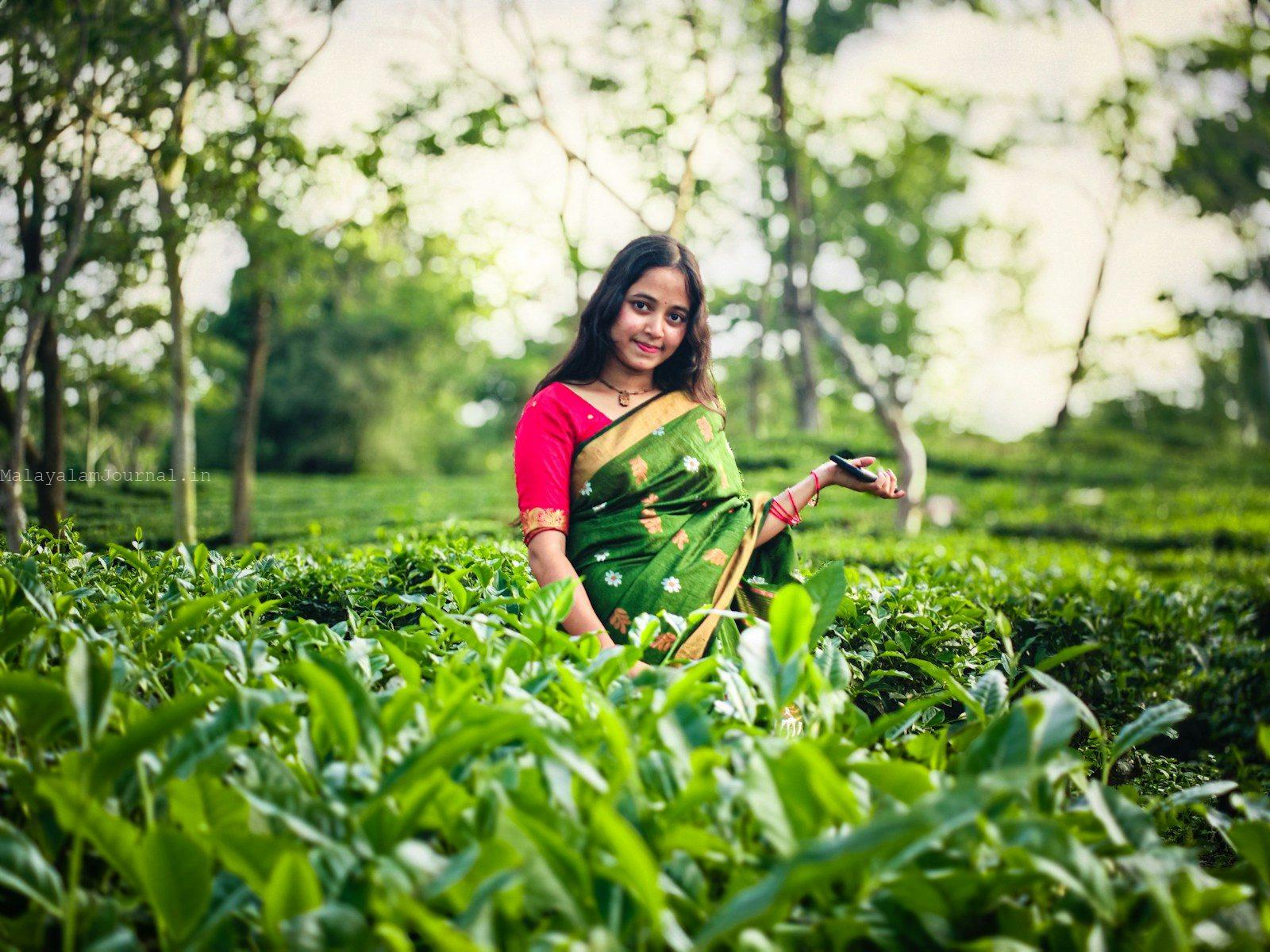 A woman smiles in a green tea garden.