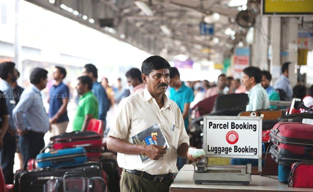 Traveler submitting documents at Indian Railway parcel service counter.
