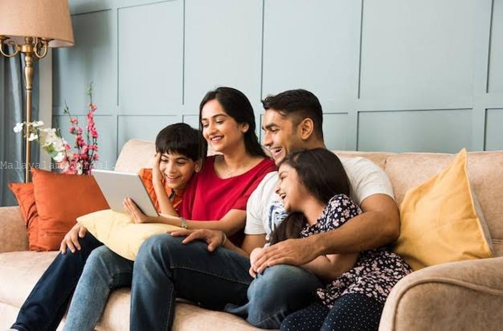 A happy Indian family sitting together on a living room sofa
