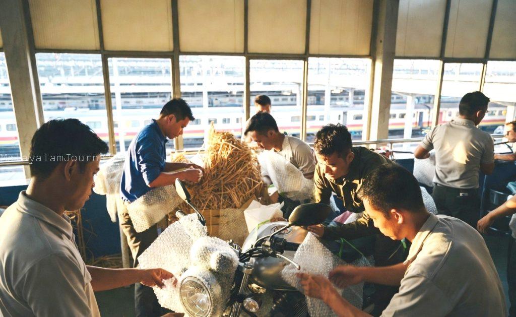 Packing process for two wheeler transport by train using protective materials.