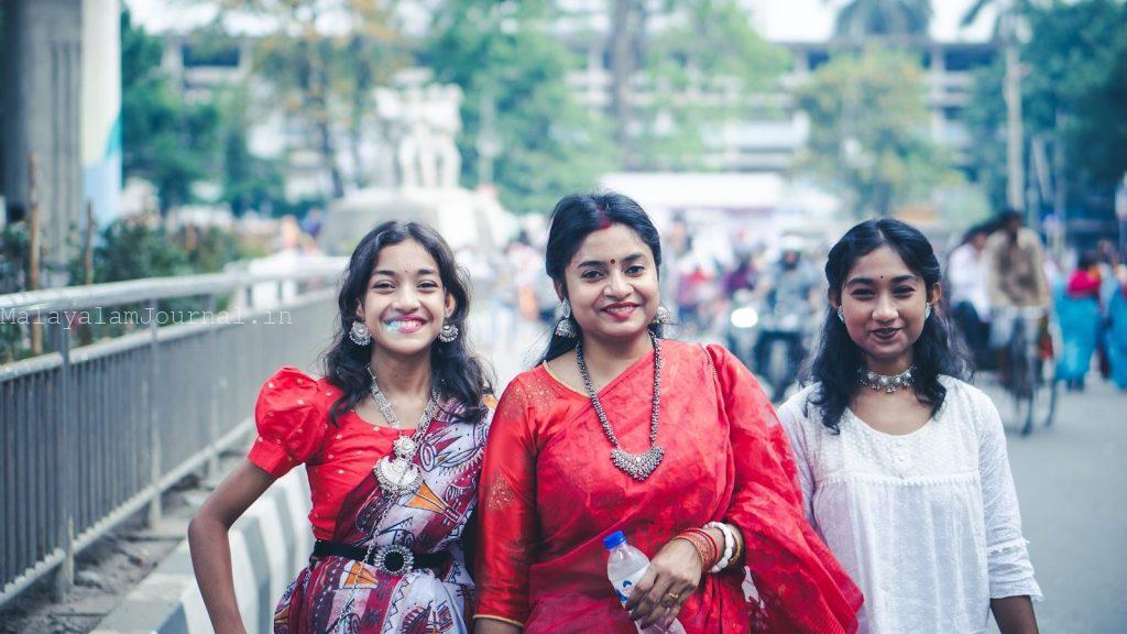Three women standing next to each other on a sidewalk