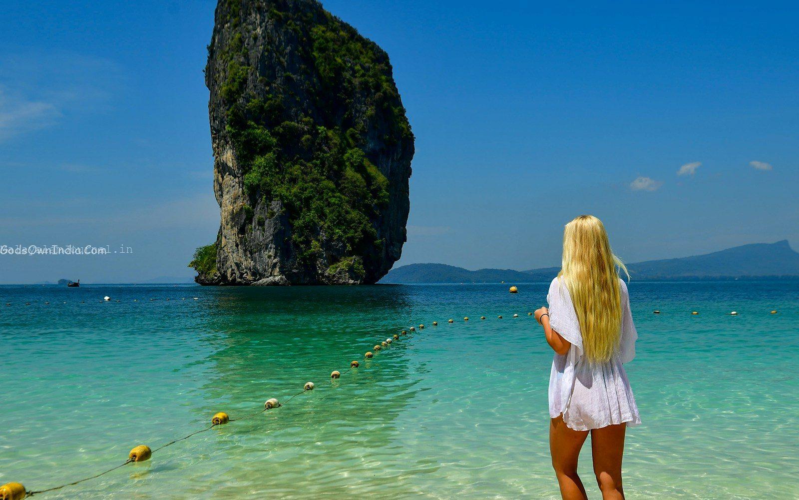 Woman in white dress looks at island in island