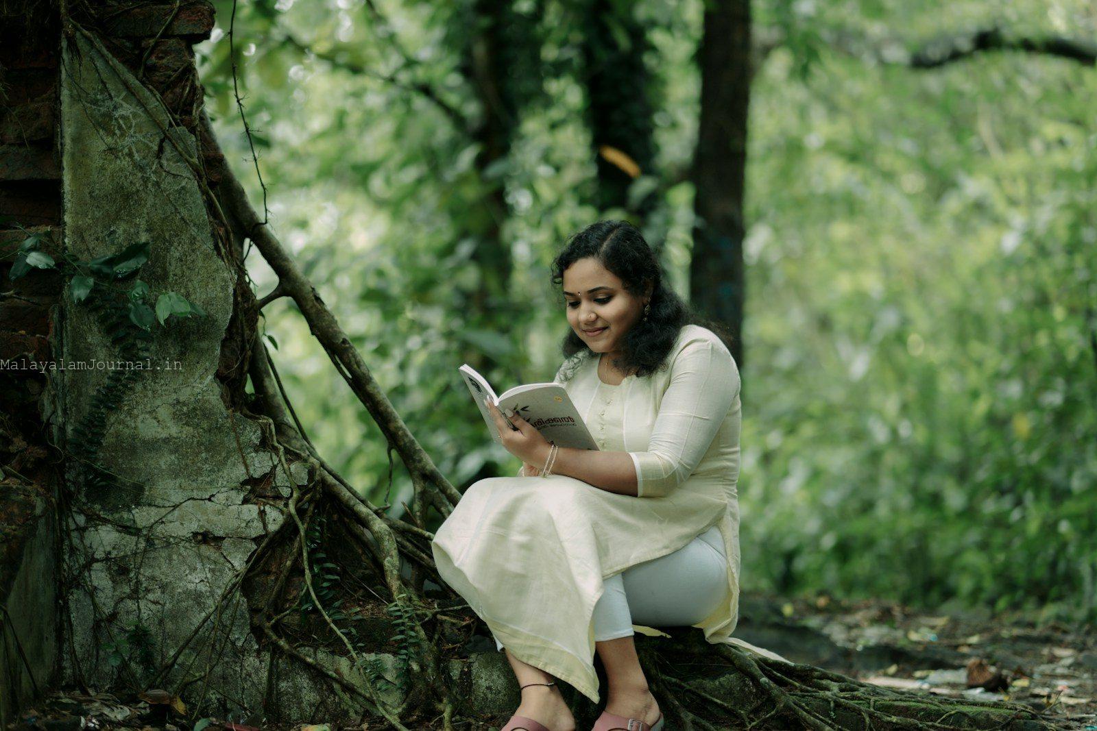 A woman in a white dress is reading a book