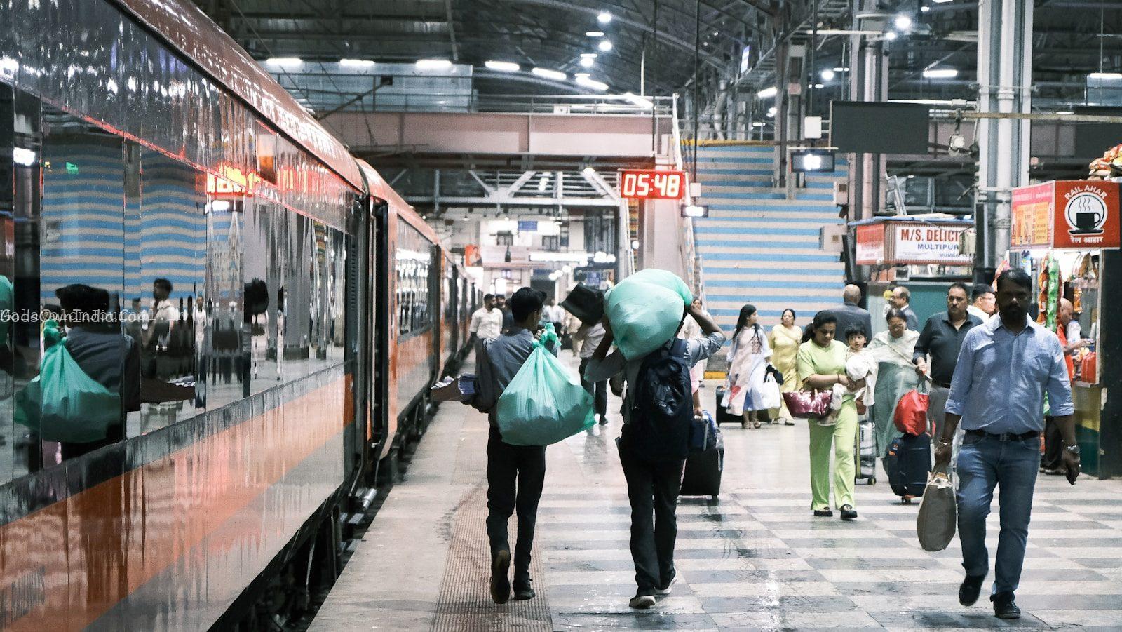 People walking on a busy train station platform.