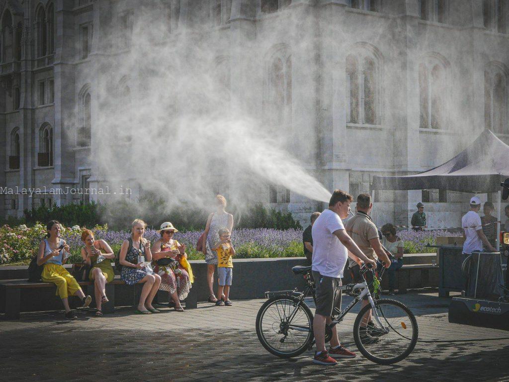 People cooling off from mist spray on a hot day